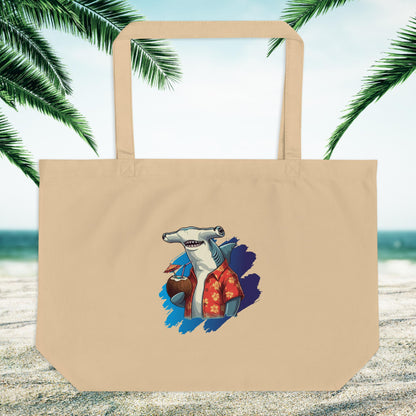 large beige eco friendly tote bag with a hammerhead shark logo on a sandy beach