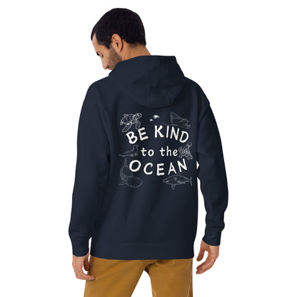 Man wearing a navy hoodie with the logo written be kind to the ocean with marine animals around it