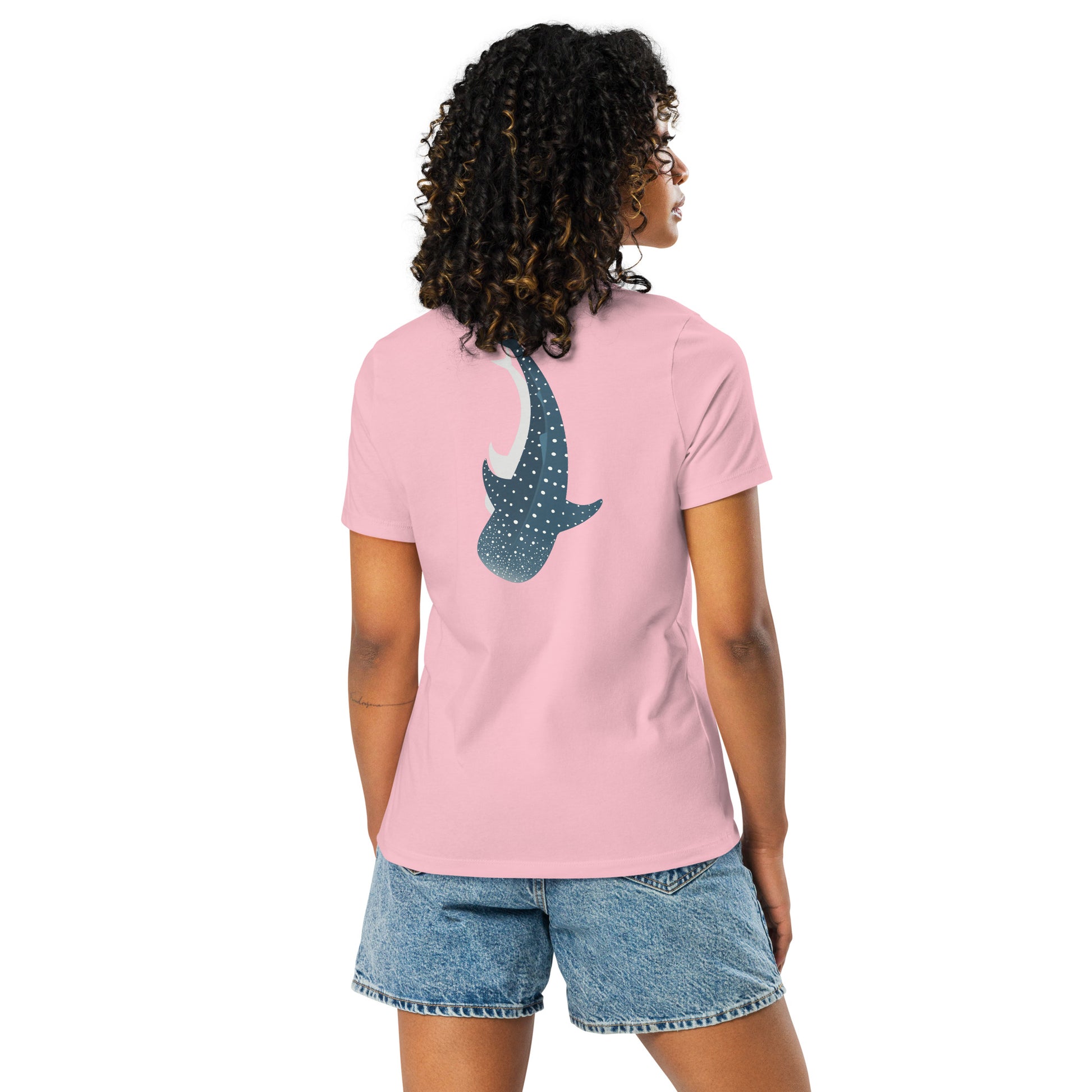 A woman wearing a light pink shirt with a large logo of a whale shark pointing down on the back side